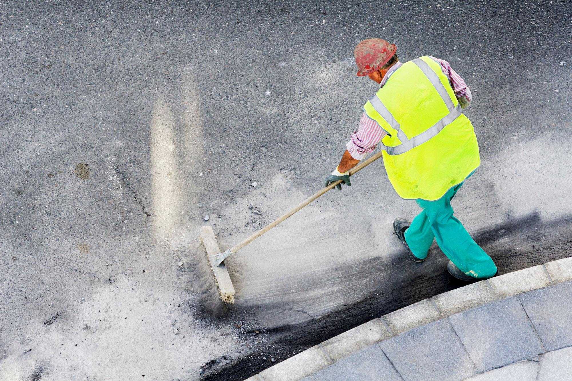 worker sweeping on construction site